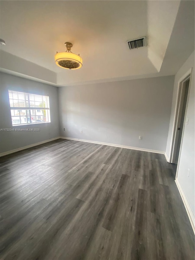 unfurnished room with dark hardwood / wood-style flooring