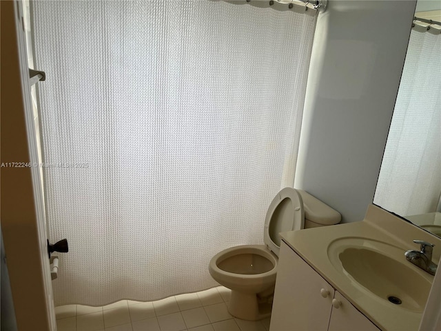 bathroom featuring tile patterned flooring, vanity, toilet, and walk in shower