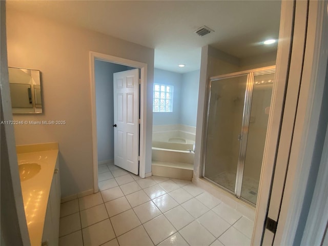 bathroom with plus walk in shower, vanity, and tile patterned flooring