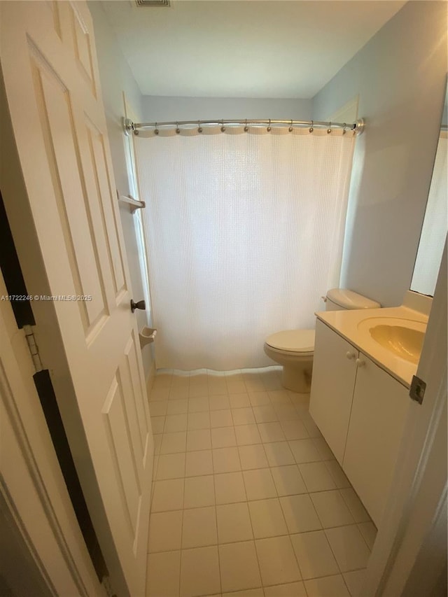 bathroom with tile patterned floors, vanity, curtained shower, and toilet