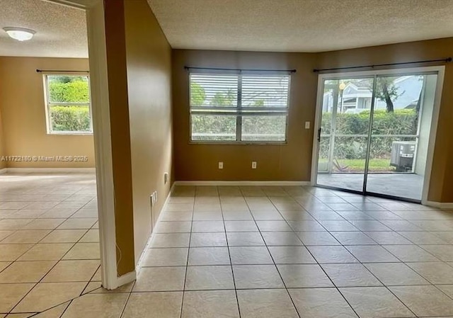 doorway with a textured ceiling and light tile patterned flooring