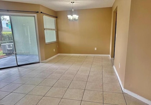 unfurnished dining area featuring light tile patterned floors, a textured ceiling, and a chandelier