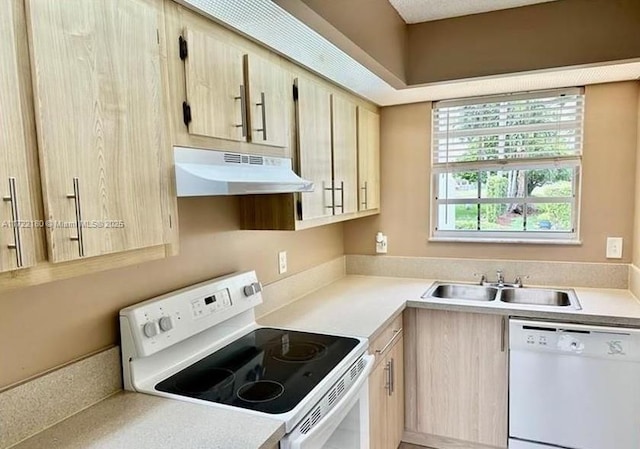 kitchen featuring light brown cabinetry, white appliances, and sink