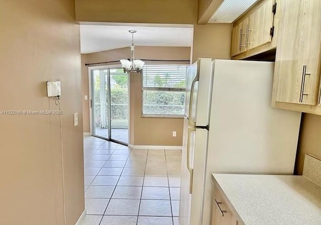 kitchen featuring light brown cabinets, white refrigerator, a chandelier, decorative light fixtures, and light tile patterned flooring