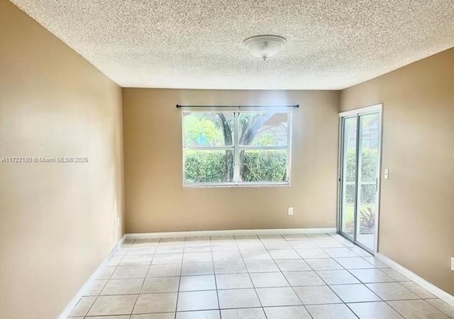 empty room featuring light tile patterned flooring and a textured ceiling