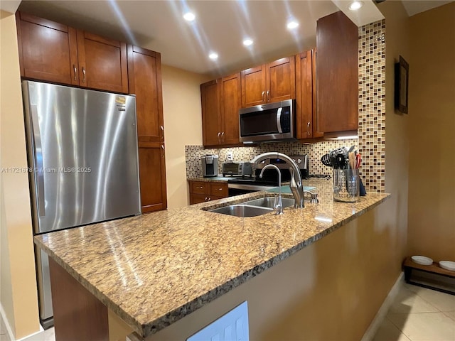 kitchen with kitchen peninsula, decorative backsplash, stainless steel appliances, sink, and light tile patterned floors