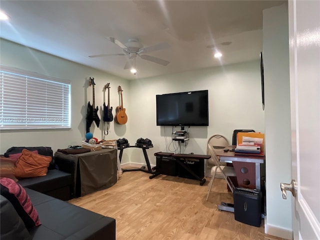 living room with light hardwood / wood-style floors and ceiling fan