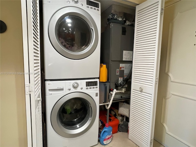 laundry room with heating unit and stacked washer and clothes dryer