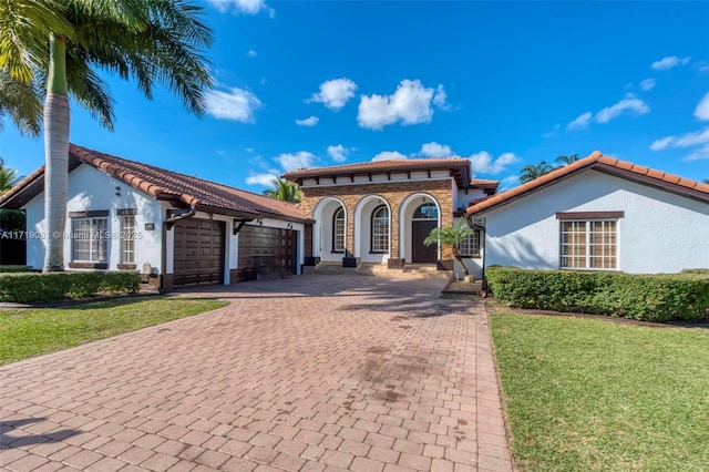 mediterranean / spanish house featuring a front yard and a garage