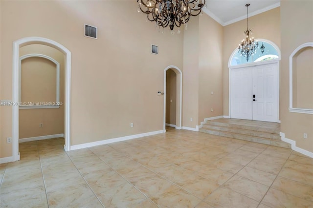 entrance foyer featuring a towering ceiling and crown molding