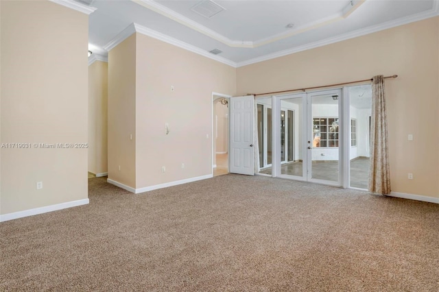 carpeted empty room featuring a raised ceiling and ornamental molding