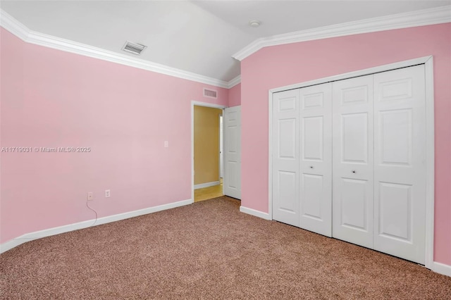 unfurnished bedroom featuring carpet flooring, lofted ceiling, ornamental molding, and a closet