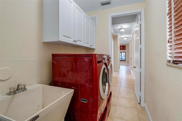 laundry room with washer and clothes dryer, cabinets, light tile patterned floors, and sink