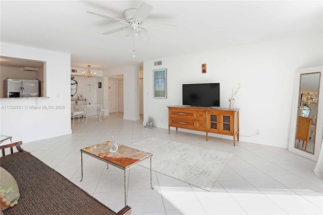 tiled living room featuring ceiling fan with notable chandelier