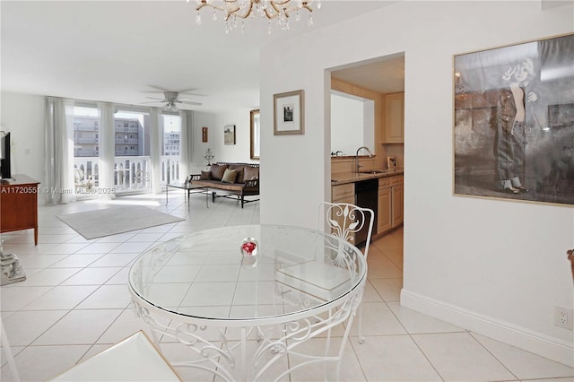 tiled dining space featuring ceiling fan with notable chandelier and sink