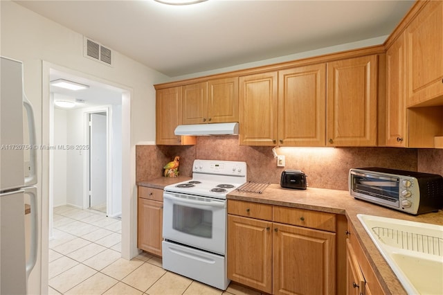 kitchen featuring tasteful backsplash, visible vents, under cabinet range hood, a toaster, and white appliances