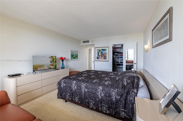 carpeted bedroom featuring visible vents and a textured ceiling