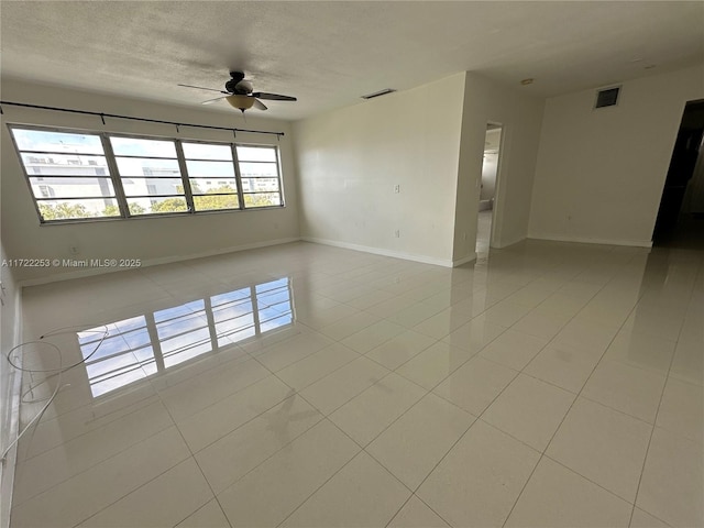 tiled empty room with ceiling fan