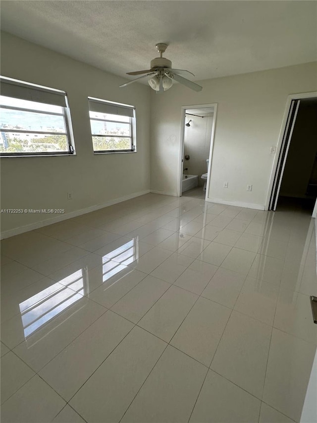 tiled spare room with ceiling fan