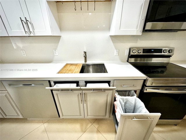 kitchen featuring range with electric stovetop, dishwasher, sink, and light tile patterned flooring