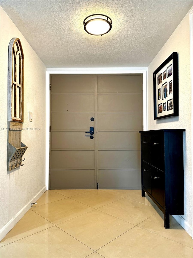 hallway with light tile patterned floors and a textured ceiling