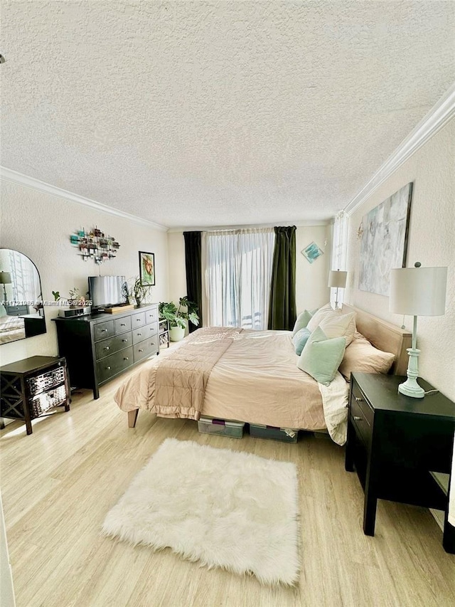 bedroom with a textured ceiling, light hardwood / wood-style floors, and crown molding