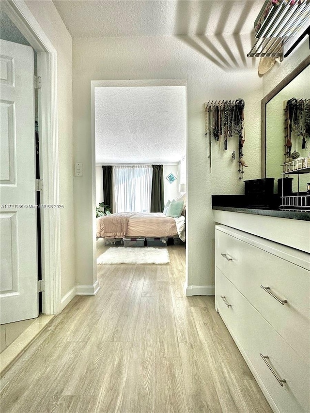 bedroom with light hardwood / wood-style floors and a textured ceiling