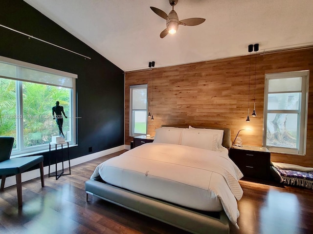 bedroom featuring ceiling fan, lofted ceiling, hardwood / wood-style floors, and wooden walls