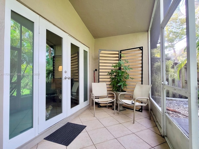 sunroom featuring lofted ceiling and french doors