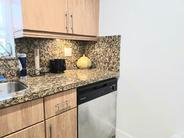 kitchen featuring dishwasher, light brown cabinetry, light stone counters, and decorative backsplash