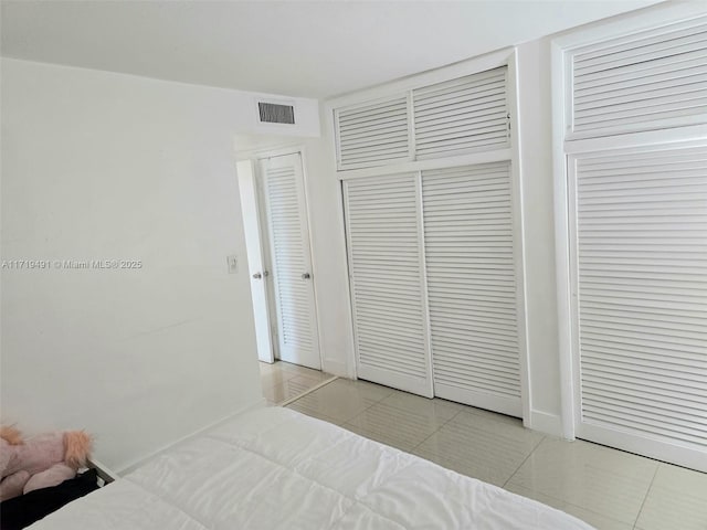 bedroom with visible vents and light tile patterned floors