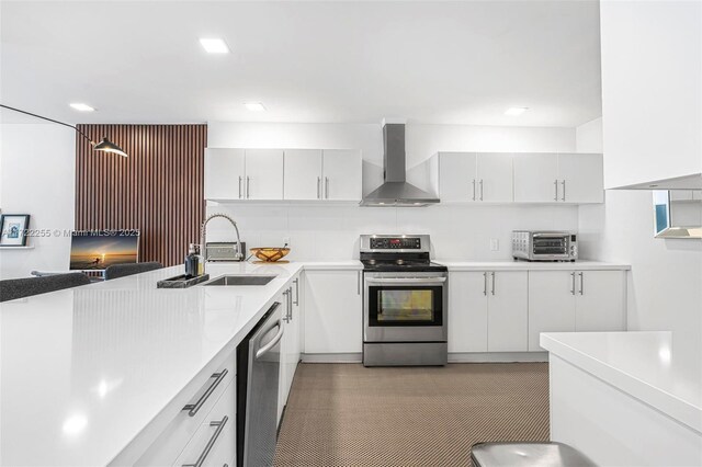 kitchen with sink, stainless steel appliances, wall chimney range hood, decorative backsplash, and white cabinets