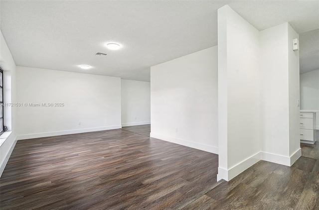 2638 NW 98th Way, Coral Springs, FL 33065 - spare room featuring dark wood-style flooring, baseboards, and a textured ceiling