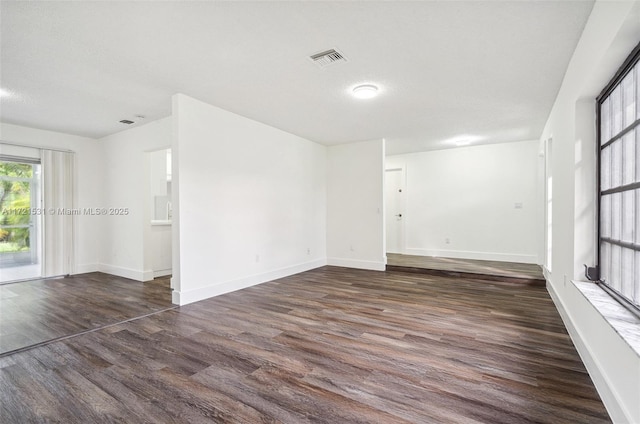 empty room with dark hardwood / wood-style flooring