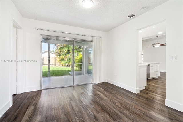 spare room with dark hardwood / wood-style floors, ceiling fan, and a textured ceiling