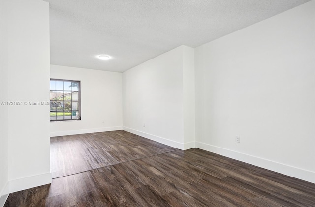 empty room featuring dark hardwood / wood-style flooring and a textured ceiling