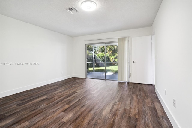 spare room with dark wood-type flooring and a textured ceiling