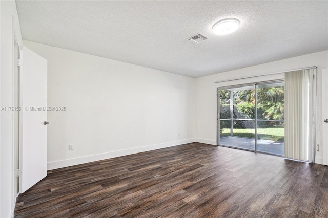 empty room with a textured ceiling and dark wood-type flooring