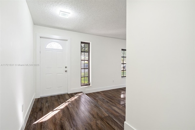 entrance foyer featuring a textured ceiling and dark wood-type flooring