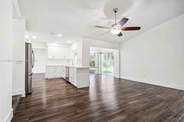 kitchen featuring white cabinetry, sink, dark hardwood / wood-style flooring, kitchen peninsula, and appliances with stainless steel finishes