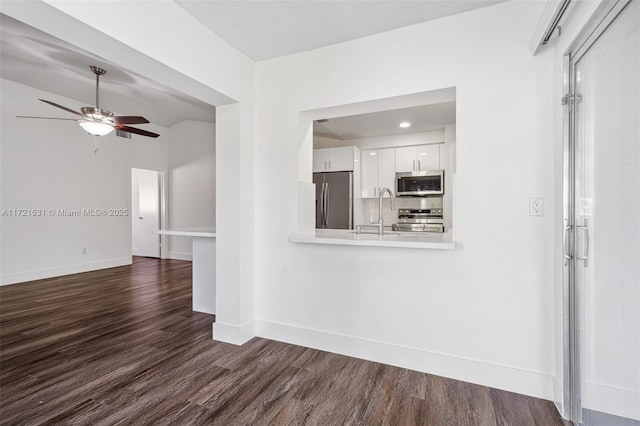 interior space with ceiling fan, dark hardwood / wood-style floors, lofted ceiling, and sink