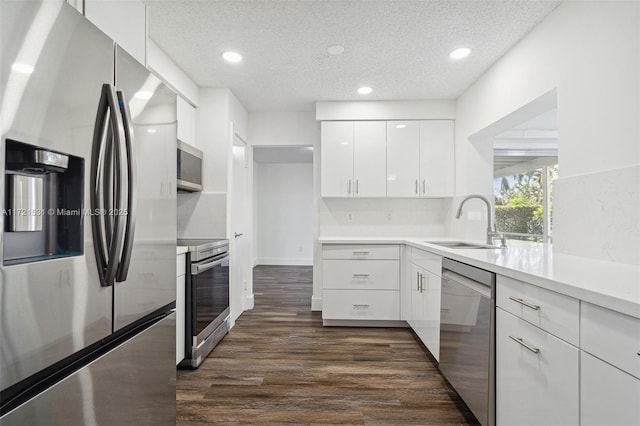 kitchen featuring white cabinetry, sink, dark hardwood / wood-style floors, a textured ceiling, and appliances with stainless steel finishes