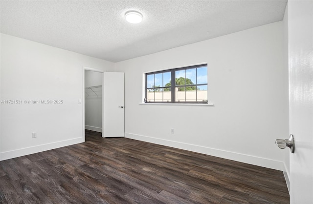 unfurnished room featuring a textured ceiling and dark wood-type flooring