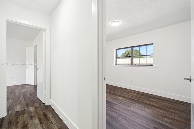 hallway featuring a textured ceiling and dark wood-type flooring