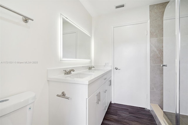 bathroom with toilet, vanity, and hardwood / wood-style flooring