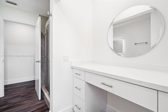 bathroom featuring vanity, wood-type flooring, and walk in shower