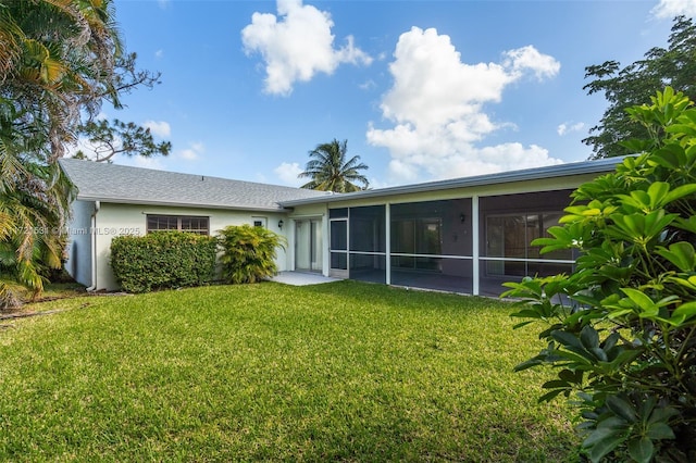 rear view of property with a sunroom and a lawn