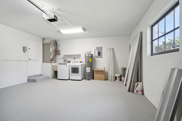 interior space with water heater, a textured ceiling, electric panel, and washing machine and clothes dryer