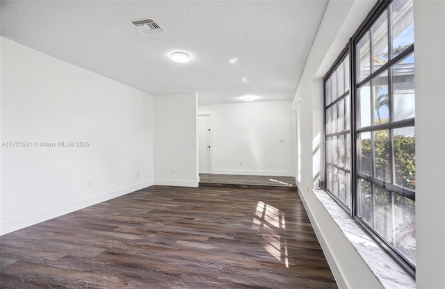 unfurnished room featuring dark hardwood / wood-style floors and a textured ceiling