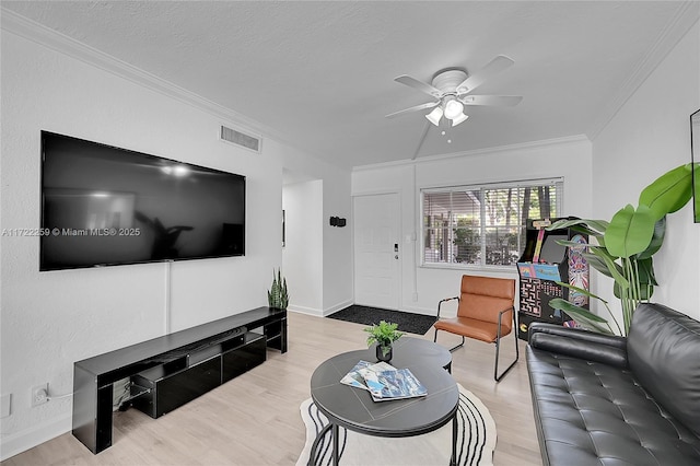 living room with hardwood / wood-style floors, ornamental molding, a textured ceiling, and ceiling fan